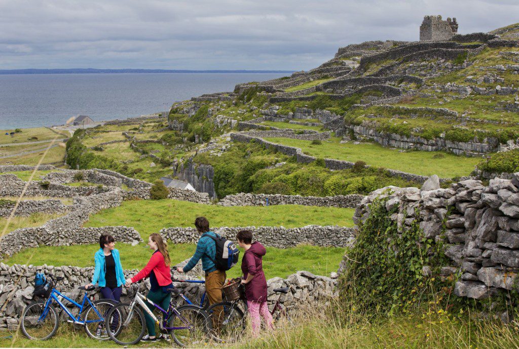 A photo of cyclists taking a brek to enjoy the view under the castle